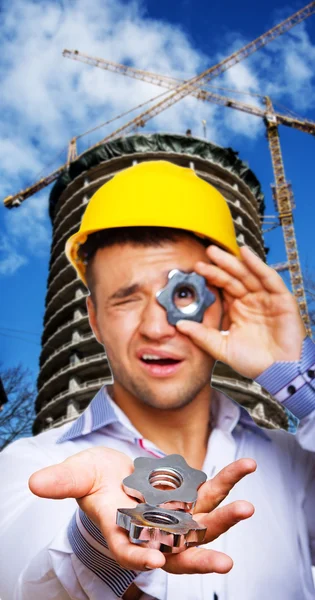 Young businessman is fooling around with screws — Stock Photo, Image