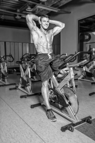Bar överkropp sportsman är att ha träning på cykel i gym — Stockfoto