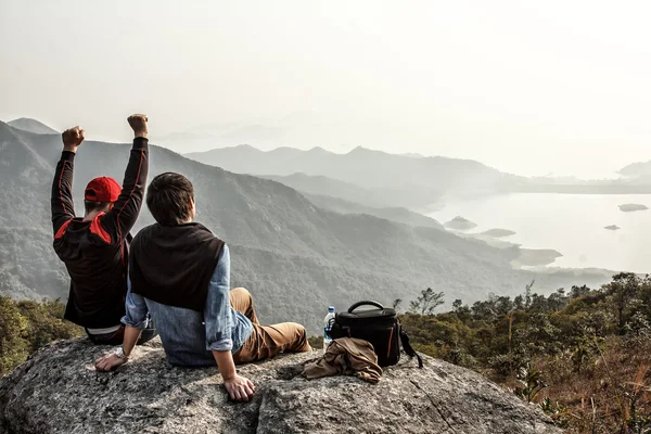 Due amici sono felici di essere arrivati in cima alla montagna — Foto Stock