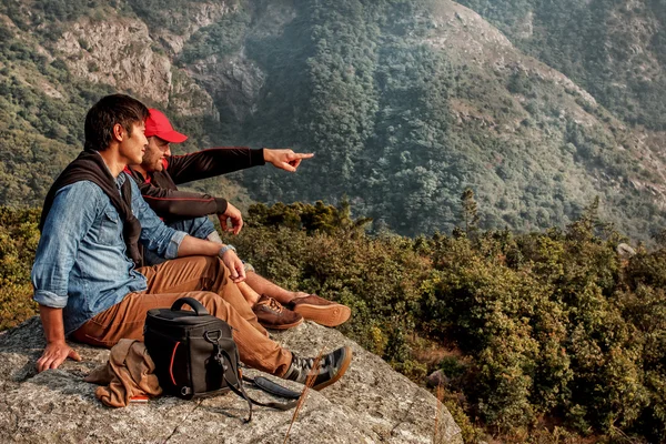 Due amici sono seduti sulla montagna e uno di loro è il punto — Foto Stock