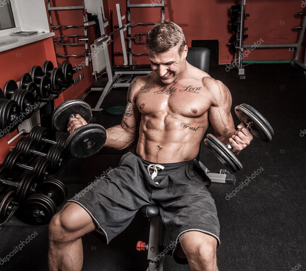 Shirtless bodybuilder is having really hard workout Stock Photo by