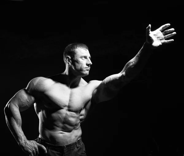 Hombre musculoso sin camisa posando sobre un fondo oscuro —  Fotos de Stock