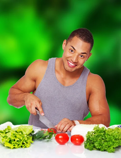 Caldo muscoloso ragazzo sta facendo insalata — Foto Stock