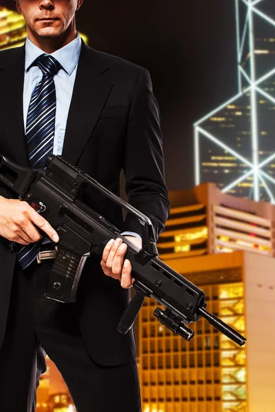 Partly seen man in suit who is holding gun — Stock Photo, Image