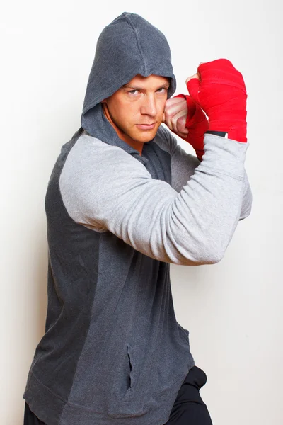 Giovane uomo di boxe è in posa su uno sfondo bianco — Foto Stock