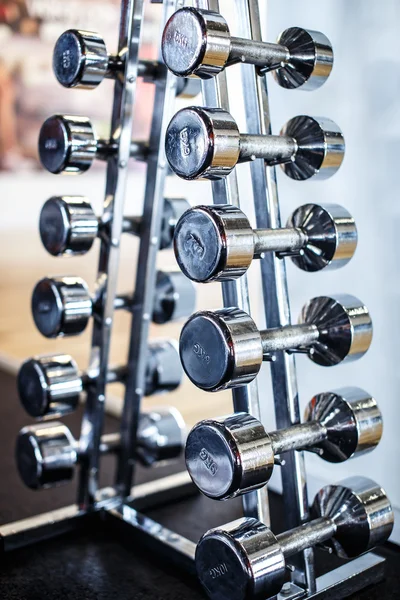 Few iron dumbbells on the stand — Stock Photo, Image