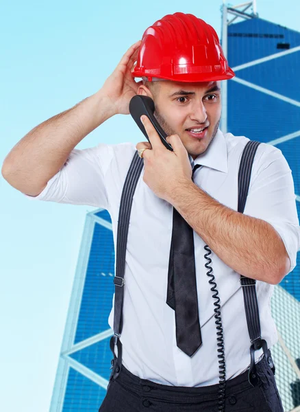 Confused worker is talking on the phone outdoors — Stock Photo, Image