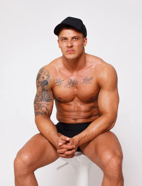 Self confident topless bodybuilder on the chair — Stock Photo, Image