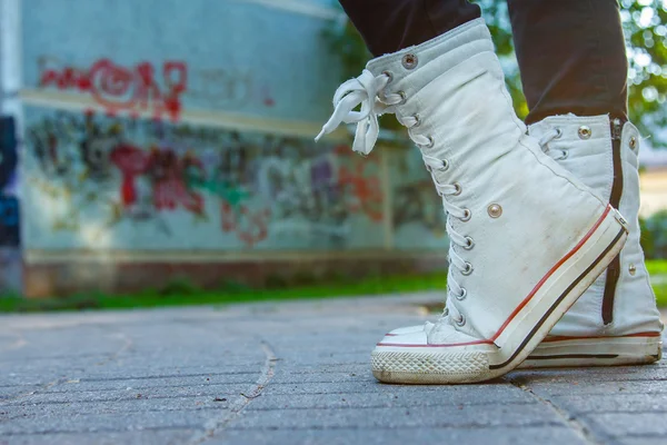 Девчачьи резиновые туфли на фоне граффити — стоковое фото