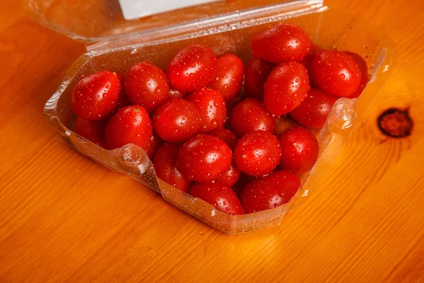 Cherry tomatoes in the plastic container on the table — Stock Photo, Image