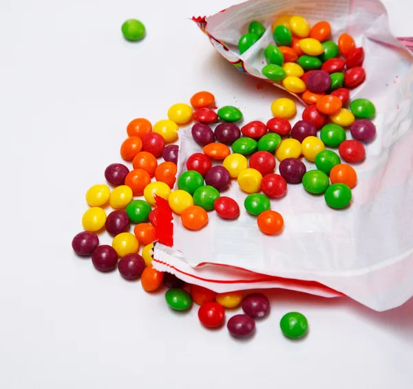 Pacote aberto que está cheio de skittles — Fotografia de Stock
