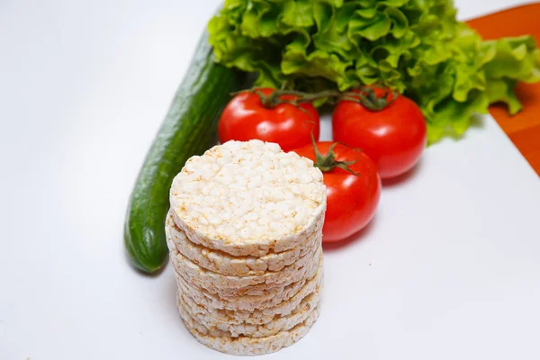 Frisches Gemüse und Maiscracker auf weißem Hintergrund — Stockfoto