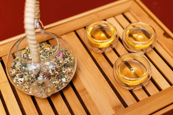 Chá de ervas e três xícaras em uma bandeja — Fotografia de Stock