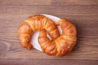 ahşap arka plan ile bir tabakta iki ay çöreği