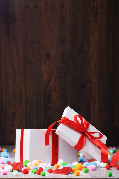 Open white gift box with colorful balls around — Stock Photo, Image