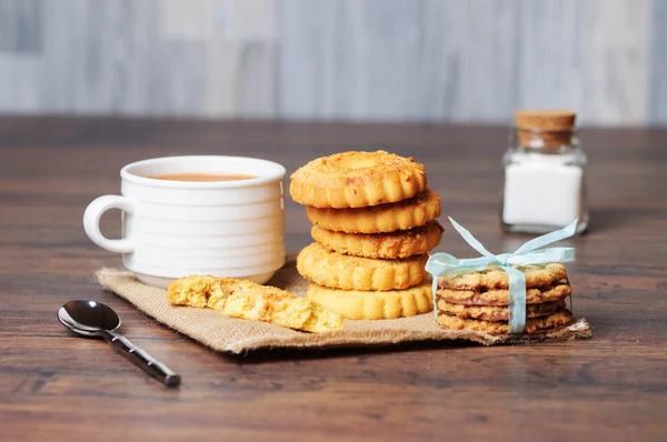 Een witte kop en cookies op een tafel — Stockfoto