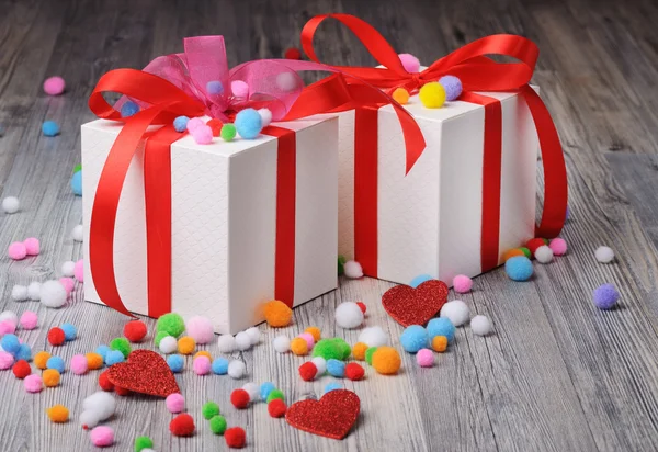 Two gift boxes and woolen pom poms on the floor — Stock Photo, Image