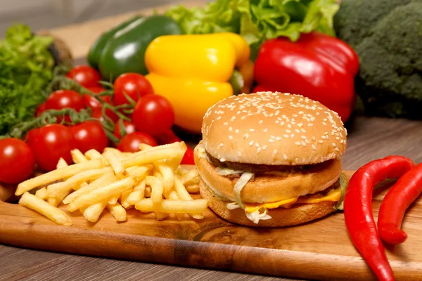 patates kızartması, hamburger ve ahşap tahta üzerinde kırmızı biber