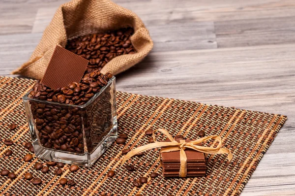 Un saco de granos de café, un frasco y chocolate — Foto de Stock