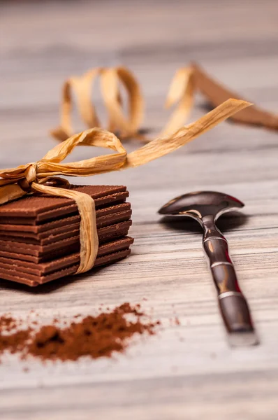 Metalen lepel en dunne chocolade met een lint — Stockfoto