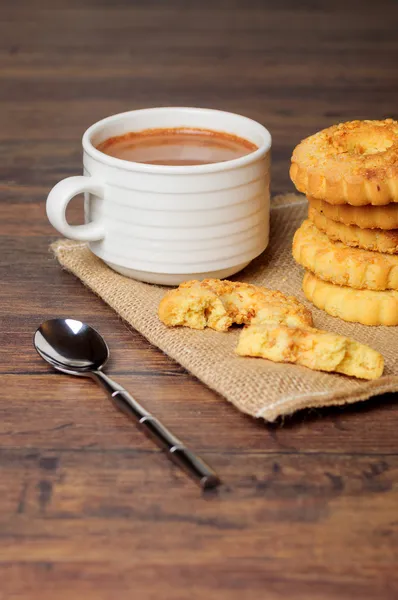 Filiżanka z plików cookie na pościel — Zdjęcie stockowe