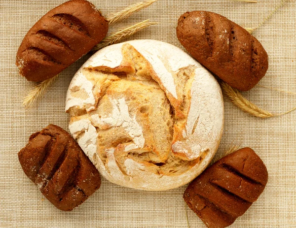 Yuvarlak bir somun ekmek, dört dikdörtgen olanlar — Stok fotoğraf