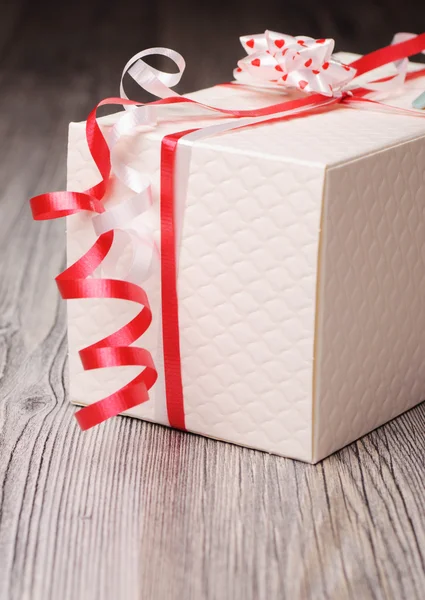 Caixa de presente texturizada branca com fitas vermelhas korker — Fotografia de Stock
