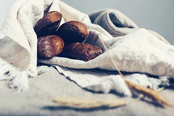 Pães escuros em pano de linho claro — Fotografia de Stock