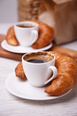 iki bardak kahve ve kruvasan yanlarında