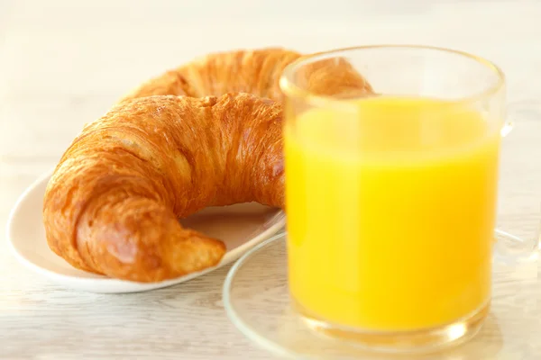 Croissants und ein Becher Orangensaft — Stockfoto