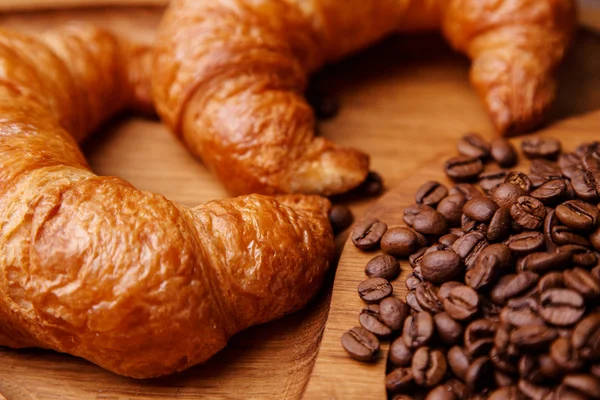 Primo piano di cornetti e chicchi di caffè — Foto Stock