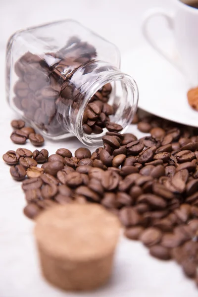 Verstreute Kaffeebohnen und ein Glas — Stockfoto