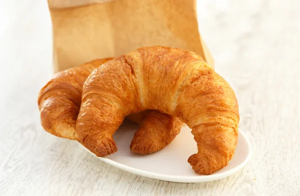 Deux croissants sur une petite assiette — Photo