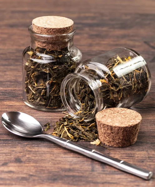 Two glass jars with tea leaves and a spoon — Stock Photo, Image