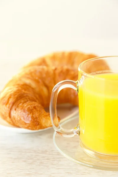 Een croissant naast een mok van SAP — Stockfoto