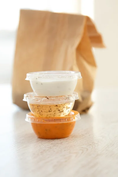 Takeaway plastic bowls with sauces — Stock Photo, Image