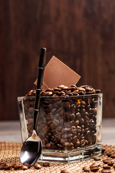 Glass pot with coffee beans and chocolate — Stock Photo, Image