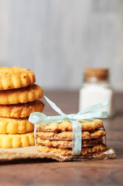 Alguns biscoitos com uma fita em linho e madeira — Fotografia de Stock