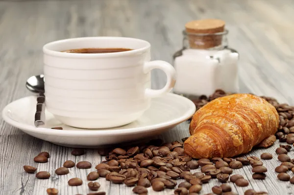 Una taza blanca y un croissant con frijoles — Foto de Stock