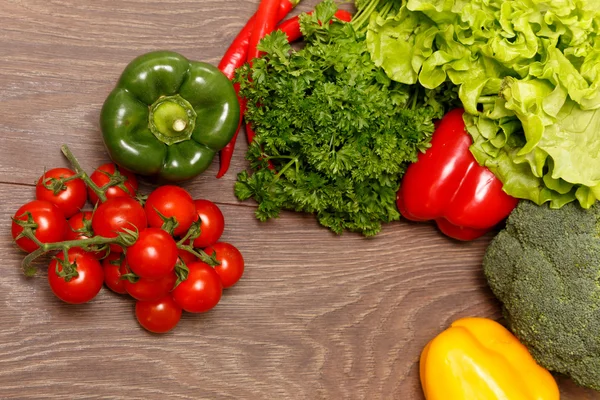 Tomatoes, paprika and other vegetables on a wooden surface — Stock Photo, Image