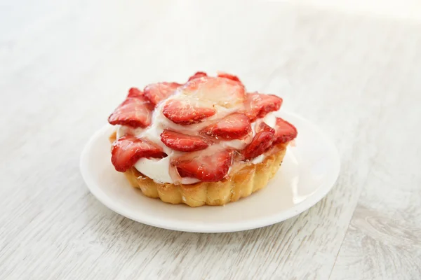 A glazed strawberry and custard tartlet on a plate — Stock Photo, Image