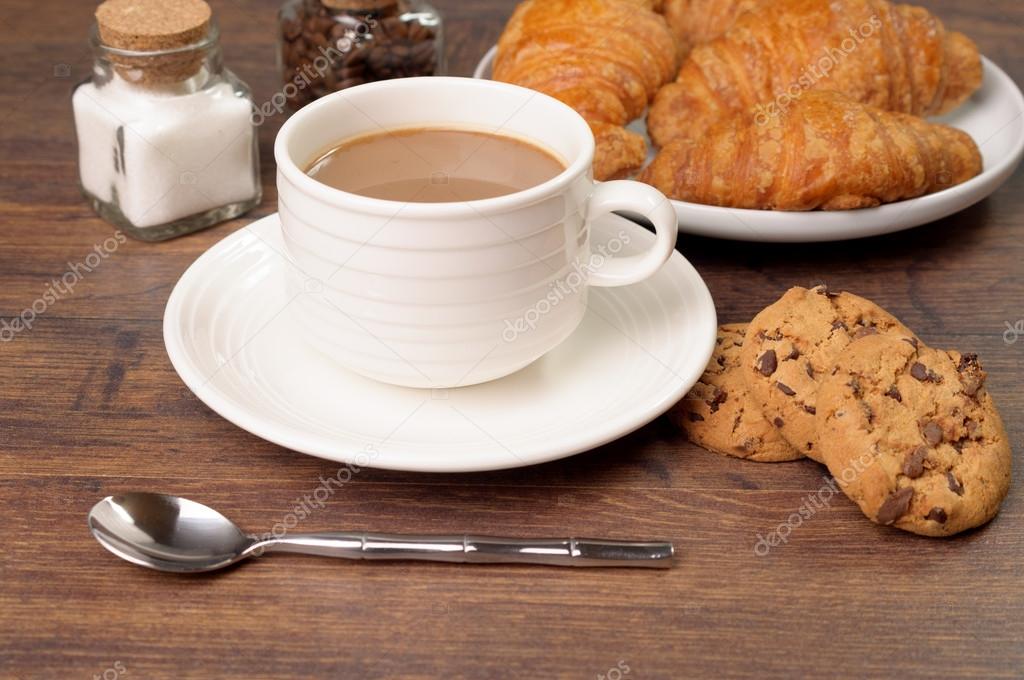 A cup of coffee with milk and pastries