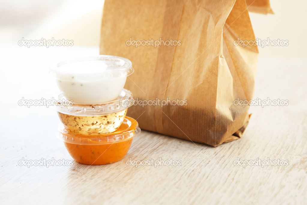 Three little plastic bowls with sauces