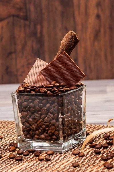 Sommige koffiebonen en stukken van chocolade in een pot — Stockfoto