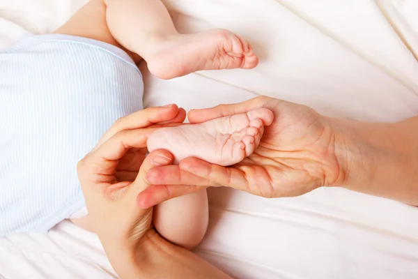 Mamma massera foten av hennes barn — Stockfoto