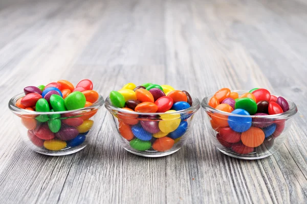 Three glass bowls with multicolored candies — Stock Photo, Image