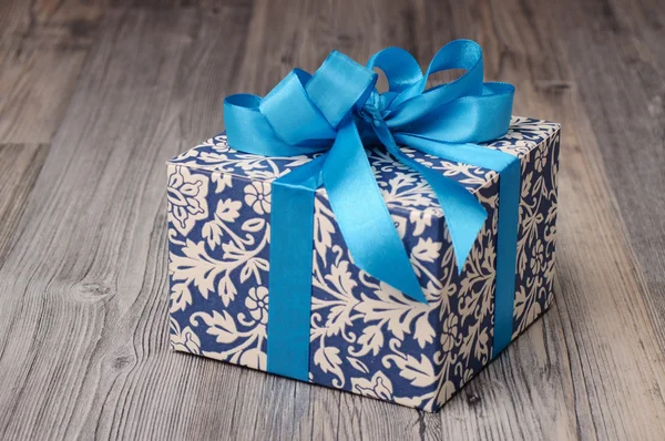 Blue patterned box with light blue ribbons — Stock Photo, Image