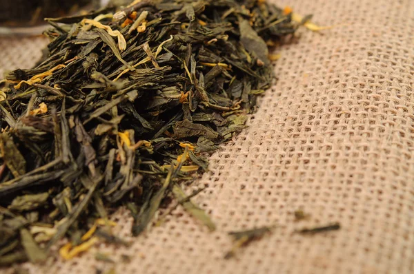 Loose green tea leaves on a linen cloth — Stock Photo, Image