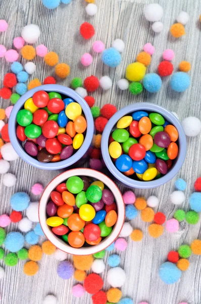 Trois pots de bonbons de couleur dure et des perles de feutre autour — Photo