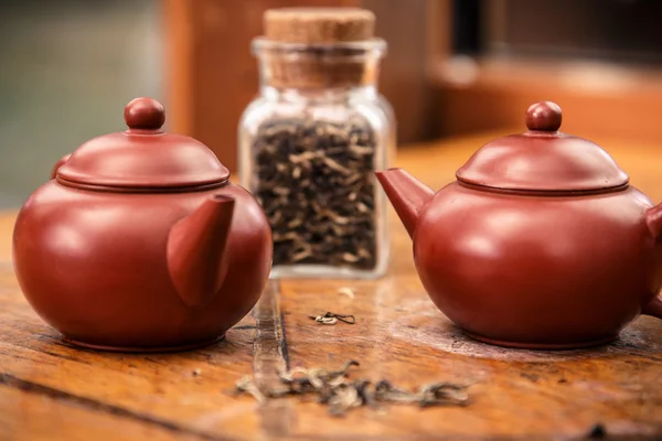 Dos teteras de barro y un frasco de té sobre madera —  Fotos de Stock